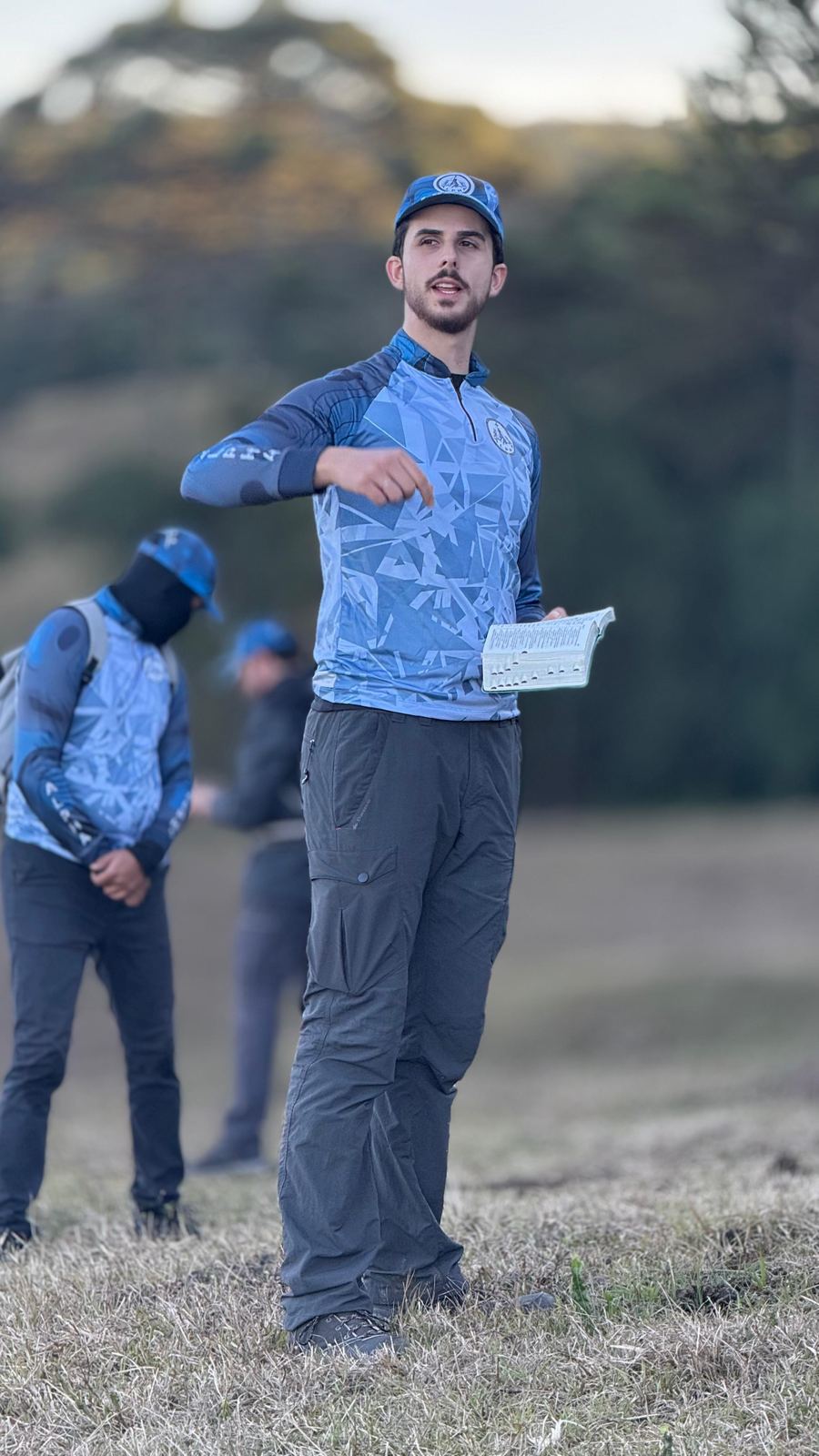 Líder orientando o grupo no campo, com um mapa na mão